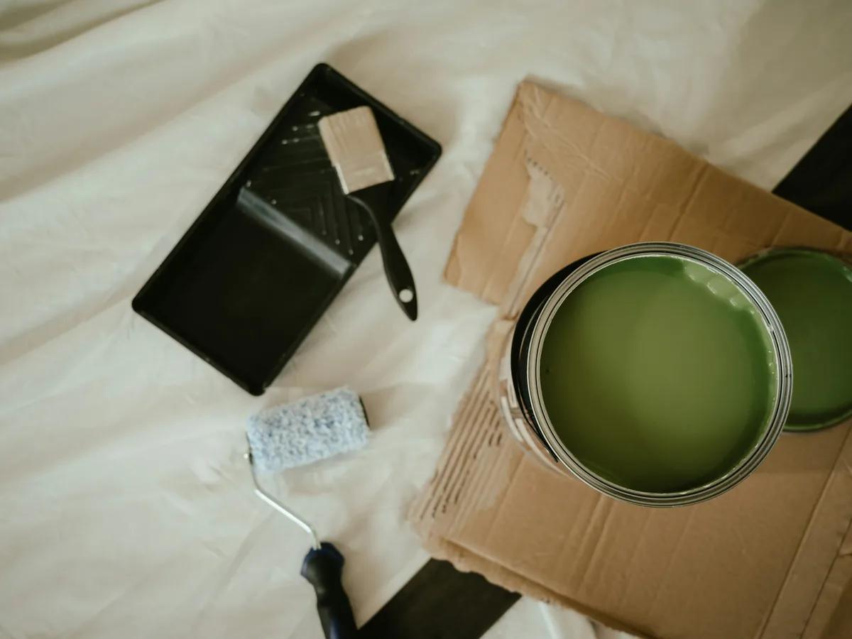 Green paint can and brush for coating preparation